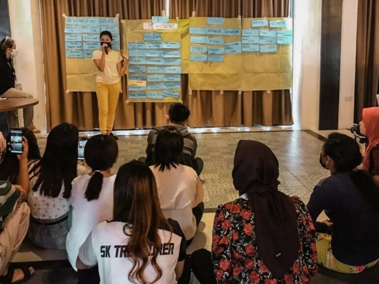 Mujer con máscara hablando con un grupo de personas