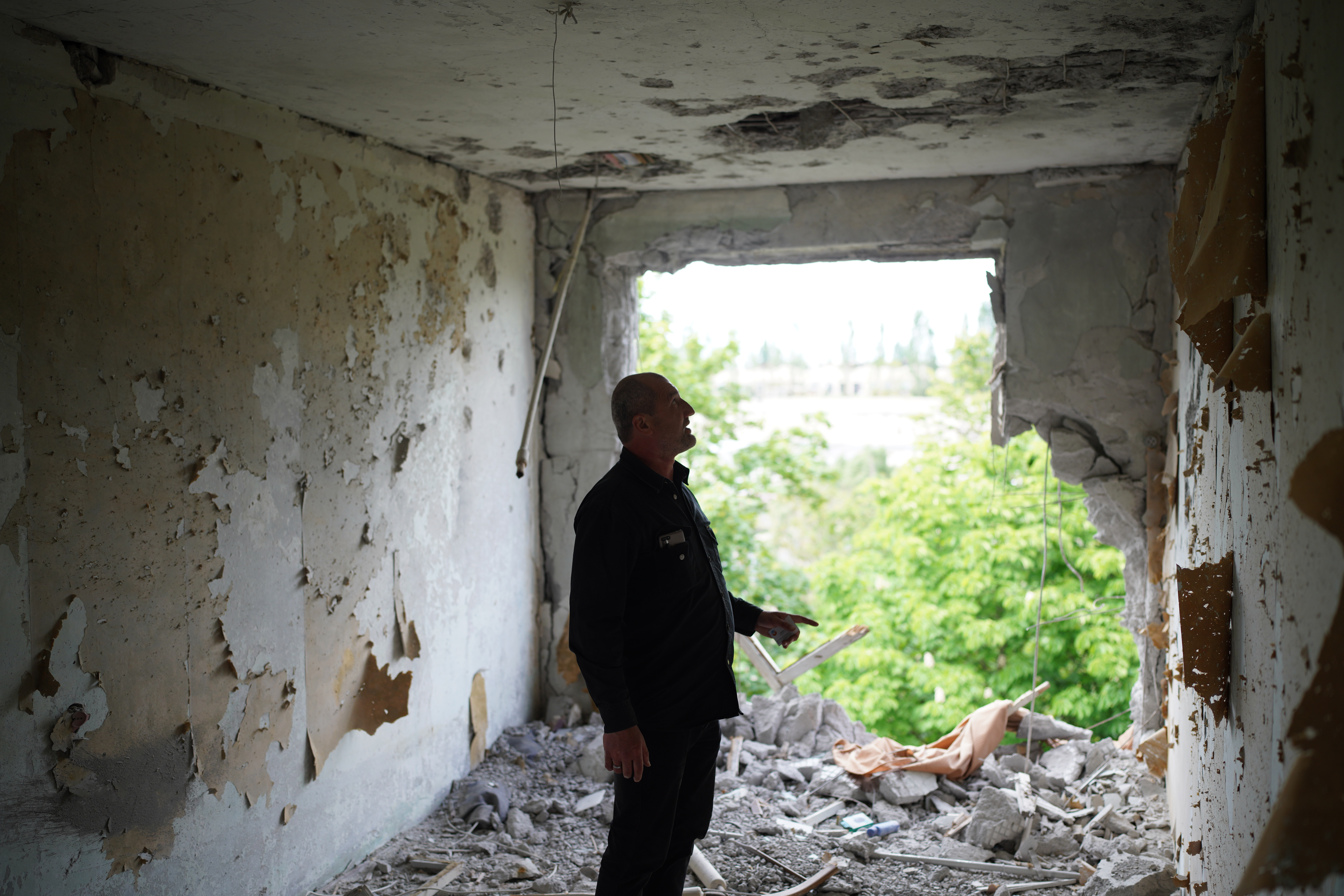 La palabra "biblioteca" está escrita en alfabeto cirílico en el edificio detrás del mercado local que se incendió en el bombardeo de la ciudad de Kharkiv por las fuerzas rusas. Ciudad de Kharkiv, Ucrania, 25 de mayo de 2022. © Tetiana Gaviuk/Nonviolent Peaceforce