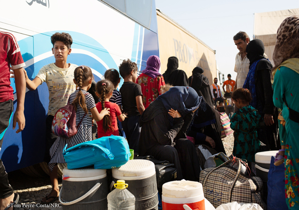 A family gathering their belongings before getting on the bus sm