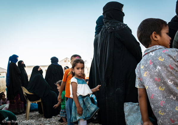 Ein junges Mädchen, das die Abaya ihrer Mutter hält, bevor es aus dem Lager sm vertrieben wird