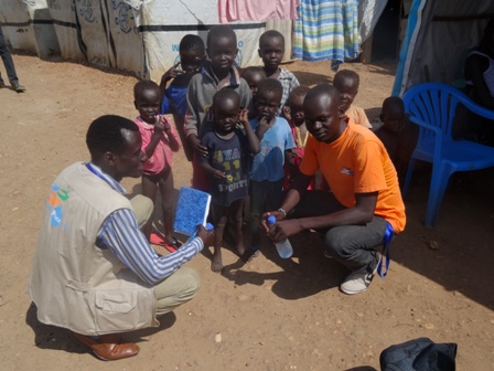 Gauche : Agents de la protection nationale, Peter et Wani avec des enfants sur le site de protection des civils de Juba. (Soudan du sud)