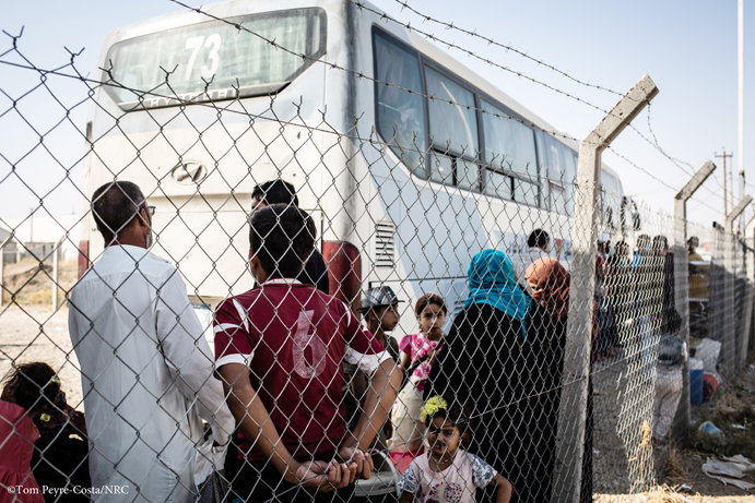 Familles faisant la queue pour monter dans le bus 