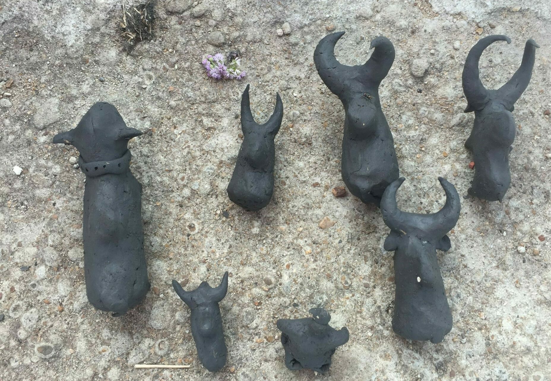 multiple clay pieces formed by the community. Some include animal lookalikes and dice.