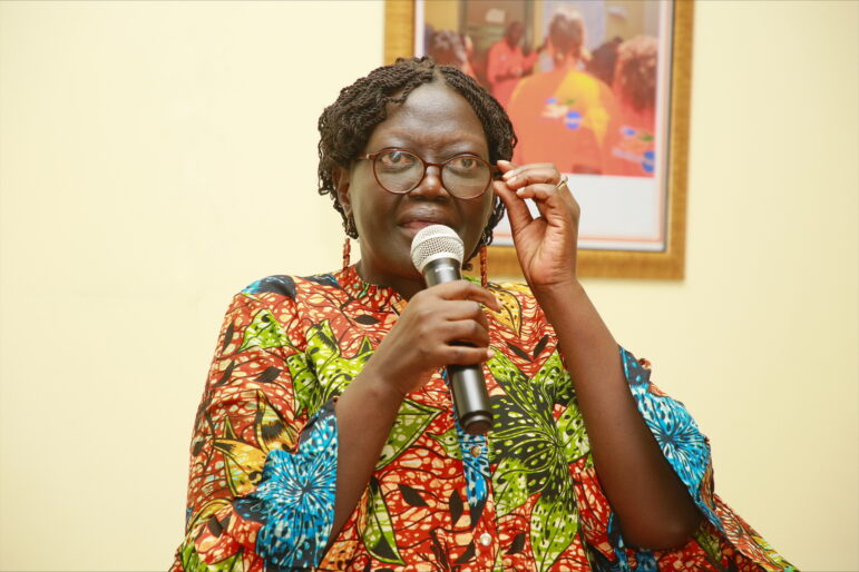 Minister Aya Benjamin speaks into a microphone.