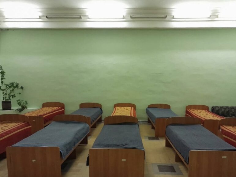 Una habitación con camas cuidadosamente dispuestas dentro de la estación de tren de Kharkiv, parte del esfuerzo de remodelación para proporcionar alojamiento seguro y cómodo para las personas desplazadas.