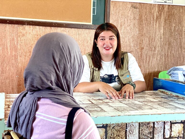 Sweetsel, a Women-Friendly Space facilitator sits while talking to a woman that is receiving assistance at the facility.