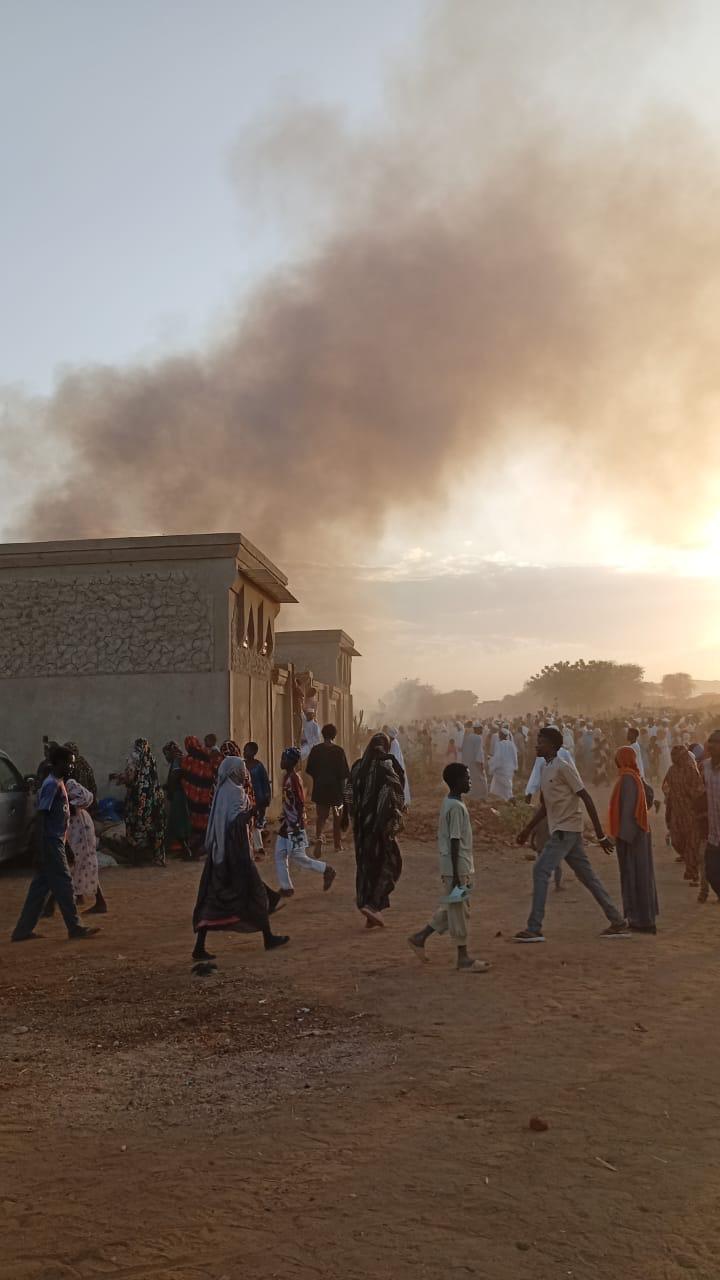 Fire outbreak in Tawila, Sudan. Large smoke clouds in the background as civilians walk along the camp.
