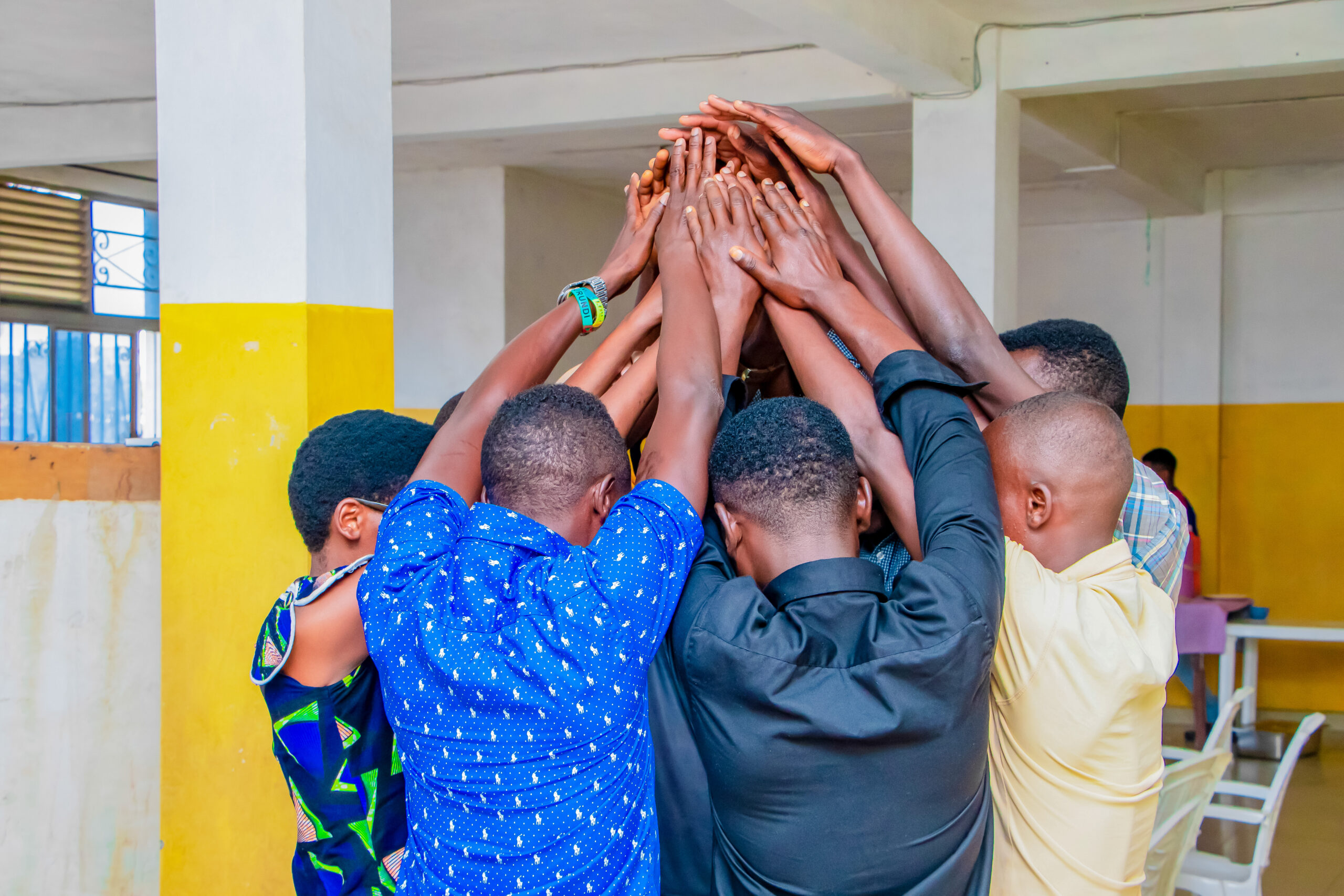 Group of training participants bringing their hands together.