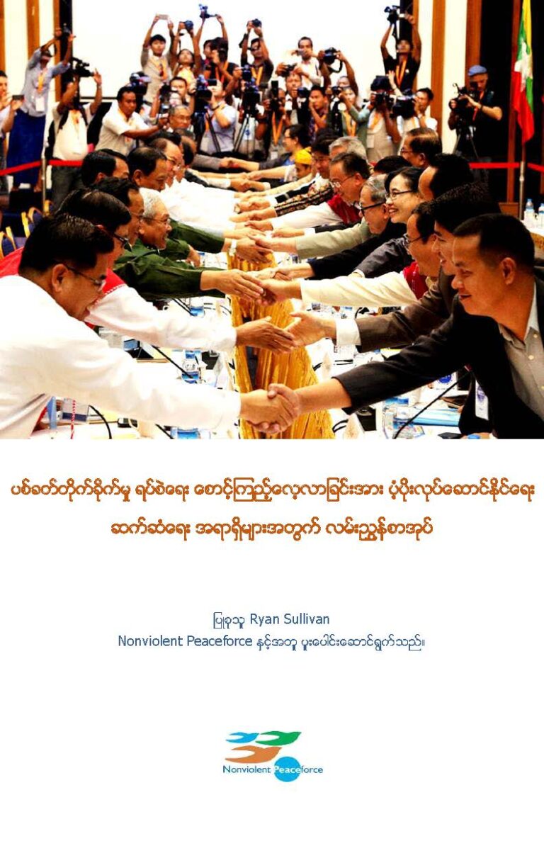 Cover of handbook. Includes text in Burmese and a photo of people standing in a line and shaking hands.